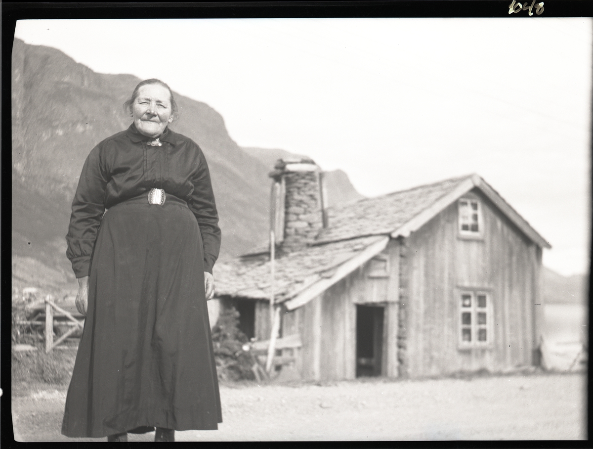 Eldre Kvinne Med Lang Svart Kjole Står Utenfor En Bygning Med Skifertak Huset Ligger Ved Veien