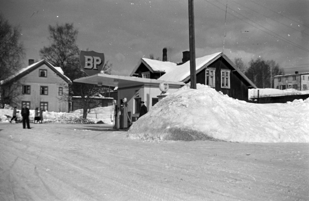 Gruppe mennesker utenfor Levernes bensinstasjon, BP- skilt ...